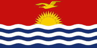 The flag of Kiribati is divided into two halves. While the upper half has a red field, at the center of which is a yellow frigate bird flying over the top half of a rising yellow sun with seventeen visible rays, the lower half is composed of six horizontal wavy bands of white alternating with blue to depict the ocean.